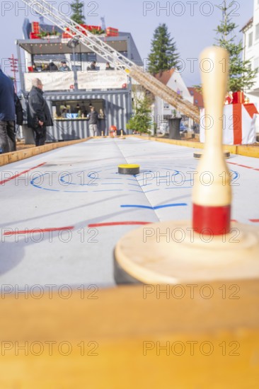 A wooden bowling game at a Christmas market with spectators standing in the background, Sindelfingen, Böblingen district, Germany