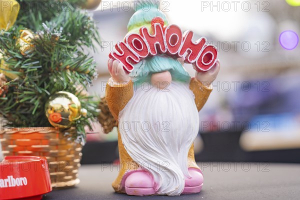 Christmas gnome with 'Ho Ho Ho' sign next to decorated Christmas tree, Sindelfingen, Böblingen district, Germany
