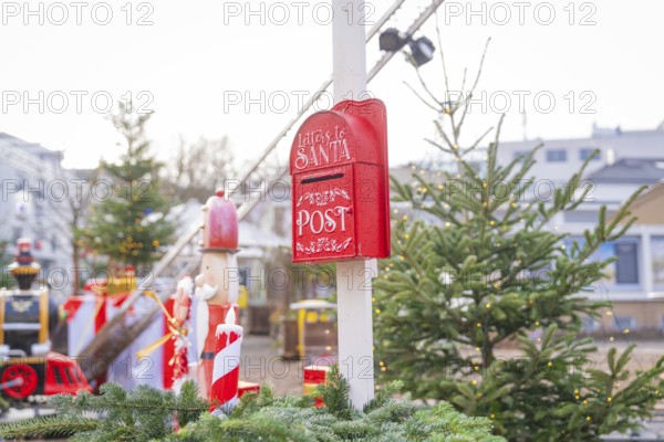 Red Christmas mailbox in front of Christmas tree and lights at a festive market, Sindelfingen, Böblingen district, Germany