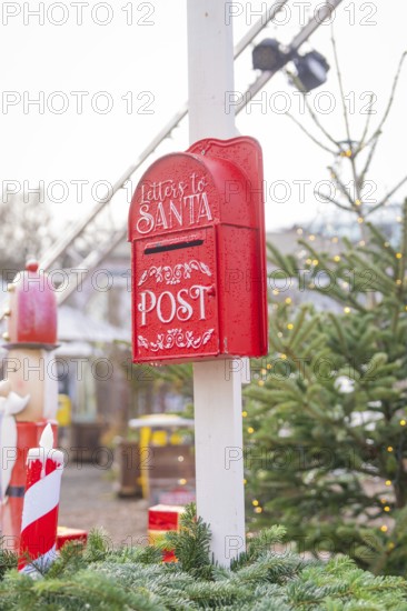 Red mailbox for Santa letters next to Christmas tree at Christmas market, Sindelfingen, Böblingen district, Germany