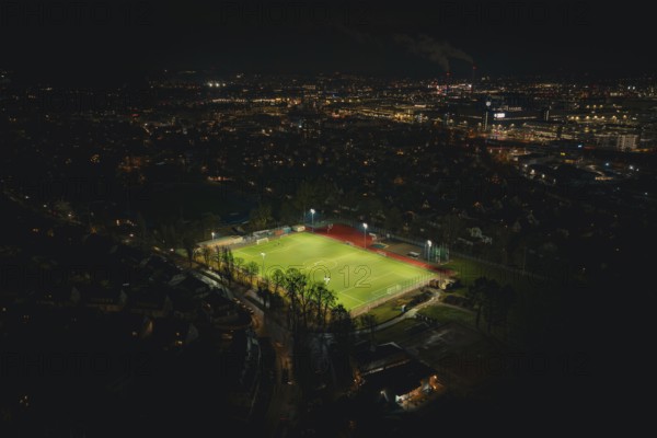 Football field at night with floodlights in urban landscape, Sindelfingen, Böblingen district, Germany