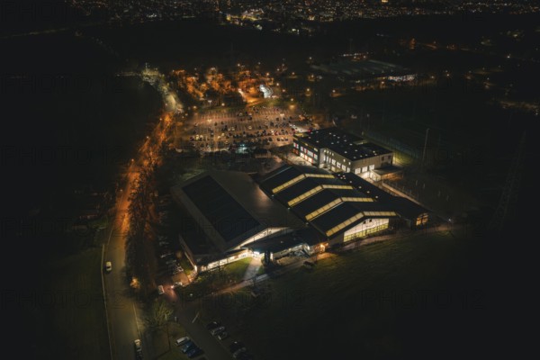 Night view of an illuminated building structure with surrounding parking spaces, Sindelfingen, Böblingen district, Germany