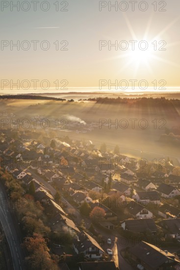 A village under golden sunlight with rays illuminating a warm autumn landscape, Gechingen, Hecken and GÃ¤u region, Calw district, Germany