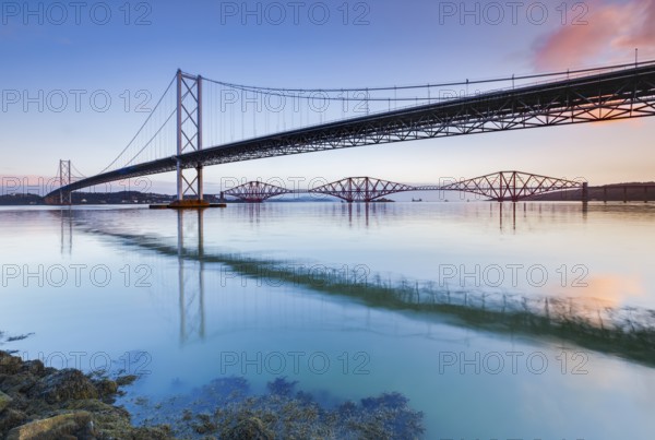 View of the Forth Road Bridge and the red Forth Bridge railway bridge at the FÃ­rth of Forth sea estuary near South Queensferry, Scotland, Great Britain