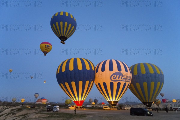 Several colorful hot air balloons rise in the morning sky over a vast landscape, Göreme National Park, Göreme Tarihî Millî Park, Nevsehir Province, NevÅŸehir, Cappadocia, Capadocia, Central Anatolia, Turkey