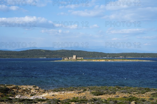 A small island with ruins is surrounded by a deep blue sea under clear skies, ruins of Agios Yorgis Monastery or St. George or Kizlar Manastiri on Dove Island, GÃ¼vercin Island, view from Alibey AdasÄ± Island, Cunda AdasÄ±, Ayvalik Islands, Ayvalik, Aegean Sea, Turkey