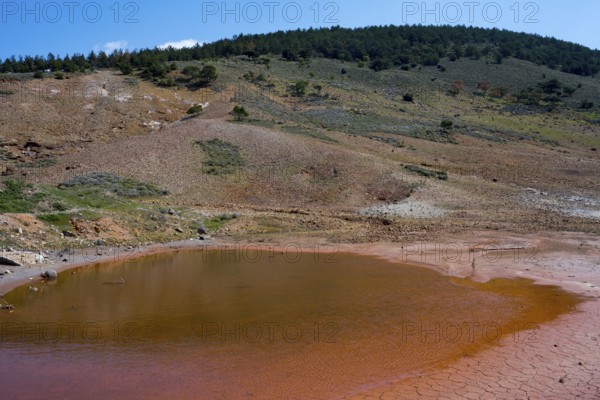 Small red lake in a geological mountain landscape under blue sky, geothermal area, rainbow rocks Tuzla, AyvacÄ±k, Ayvacik, Ã‡anakkale, Canakkale, Turkey
