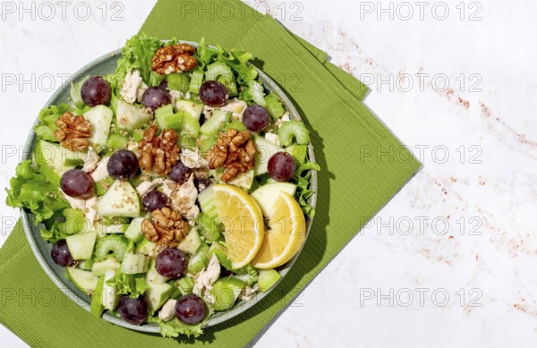 Fresh Waldorf salad, celery stalk with chicken, apple and walnuts, grapes, herbs, homemade, without people