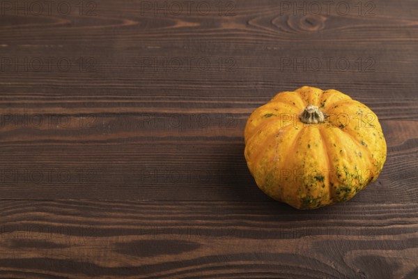 Orange Pumpkin on brown wooden background. Side view, copy space. healthy food, vegetable, minimalism