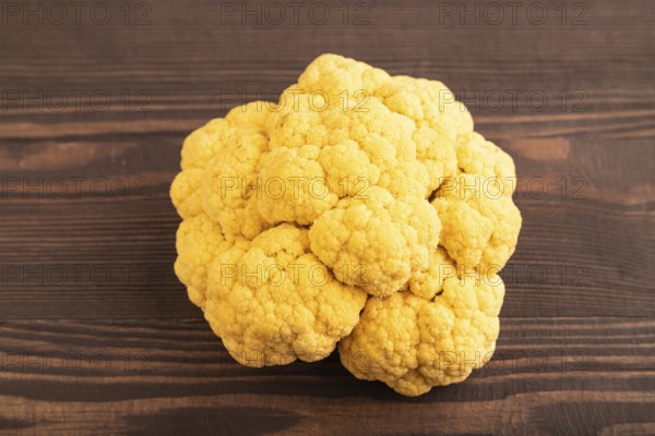 Yellow Cauliflower on brown wooden background. Side view, close up. healthy food, vegetable, minimalism