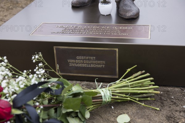 Red roses with a mourning ribbon lie in front of the Walter LÃ¼bcke memorial during the construction of Walter LÃ¼bcke Platz in front of the Konrad Adenauer Haus, the party headquarters of the Christian Democratic Union (CDU) on 2 December 2025. The square was built by the Centre for Political Beauty (ZPS) and approved by the Berlin Mitte district authority for two years. Walter LÃ¼bcke was a member of the Hessian state parliament for the CDU and was murdered by an AfD supporter on 2 June 2019