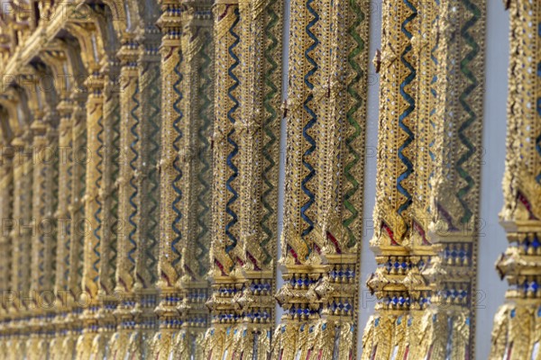 Columns with mosaic decorations (Lai Kranok), also: golden, mosaic-decorated Thai temple columns (Sao), decorated in the Lai Kranok style, typical of Rattanakosin architecture (Bangkok style), on the outer faÃ§ade of the Ubosot (ordination hall), Wat Chana Songkhram, Phra Nakhon, Bangkok, Thailand