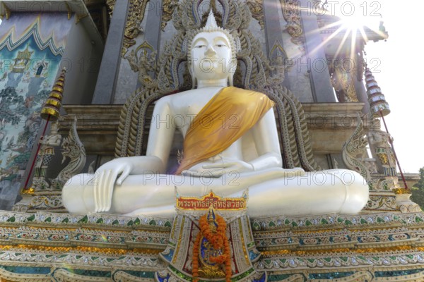 Buddha statue with tunic, Bhumispara mudra, Buddha Gautama at the moment of enlightenment, at the entrance to Wat Sitthawararam, Bangkok, Thailand