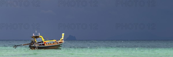 Longtail boat (Thai: Ruea Hang Yao) on the beach, behind it an approaching thunderstorm, Koh Ngai Island, Andaman Sea, Satun Province, Southern Thailand, Thailand