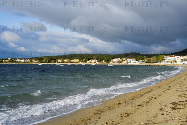 A beach with soft waves, cloudy skies and houses along the coast, beach near GÃ¼zelyali, GÃ¼zelyalÄ±, Ã‡anakkale, Canakkale, Marmara region, Turkey