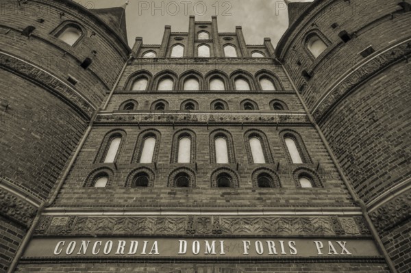 Concodia Domini Fotris Pax: The harmony of the Lord, the peace of the father, a saying at the Holsten Gate, historic city gate from 1478, sepia, Holstentorplatz, Hanseatic City of LÃ¼beck, Schleswig-Holstein, Germany