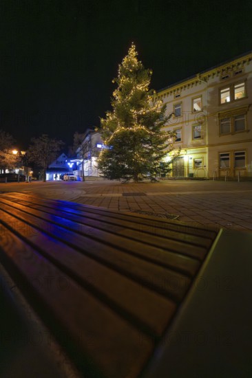 A festively illuminated tree at night, bench in the foreground, Aidlingen, Böblingen district, Germany