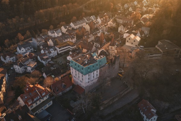Aerial view of a village in the golden light of sunset, with a distinctive castle, Dillweisenstein, Pforzheim, Germany