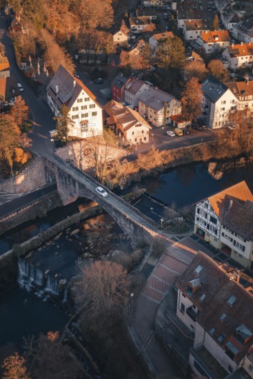 Aerial view of a bridge across a river in an autumnal village, Dillweisenstein, Pforzheim, Germany