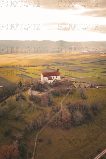 Church on a hill with extensive views of fields and forests in warm light, Wurmlinger Chapel, Rottenburg am Neckar, Germany