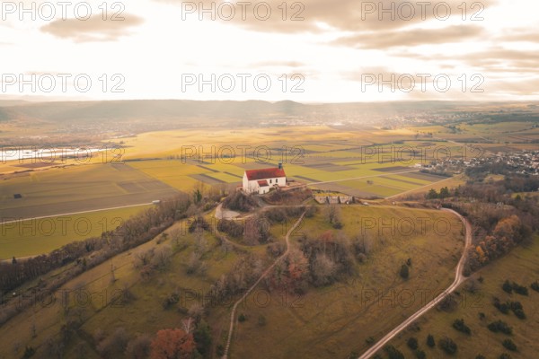 Panoramic view of a church on a hill with surrounding fields and vast clouds, Wurmlinger Chapel, Rottenburg am Neckar, Germany