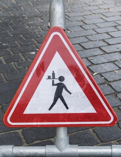Triangular warning sign on cobblestones depicting a stylized figure with a tray, province of Friesland, the Netherlands