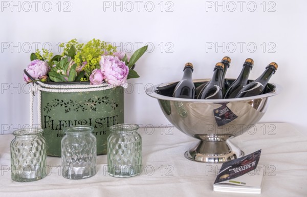 Flower arrangement and bottles in a wine cooler on a table, Rhineland-Palatinate, Germany