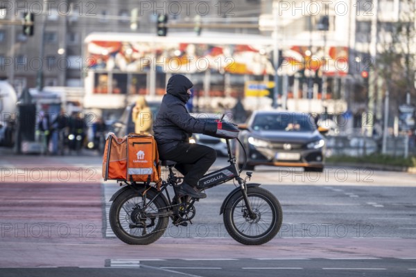 Lieferando delivery service driver, with moped-style e-bike, fat bike, model Koolux, at delivery, AlexanderstraÃŸe, Berlin