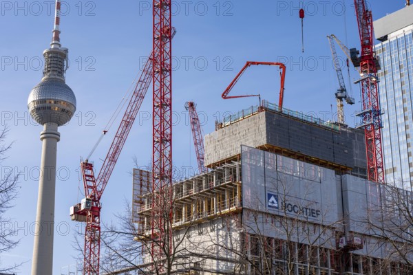 Construction site of the Covivio high-rise building at the front, in the vicinity of Alexanderplatz in Berlin, mixed use of apartments, offices, retail and a daycare center, the high-rise construction site of The Berlinian office high-rise building, dome of the Berlin TV Tower, Germany