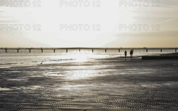 People on the beach at a pier, sunrise, Scharbeutz, 29.11.2025, Scharbeutz, Schleswig-Holstein, Germany