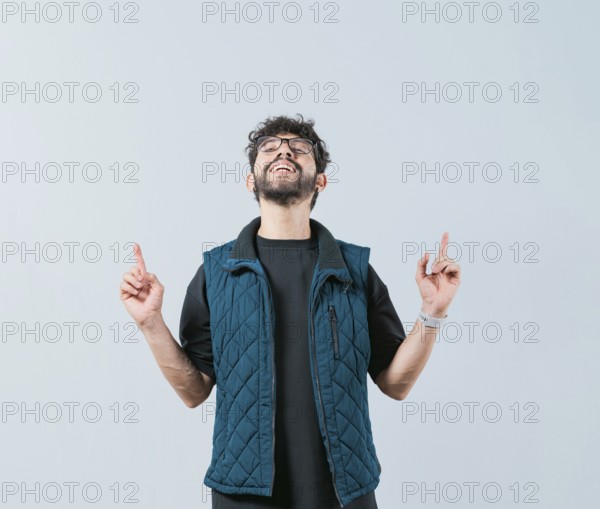 Handsome man in glasses pointing an advertising up isolated. Young man pointing blank space up and smiling