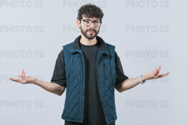 Confused man spreading hands bewildered isolated. Unsure person with face worried