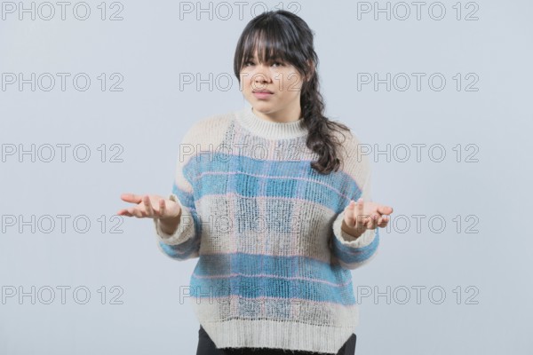 Confused asian woman spreading hands bewildered isolated. Unsure female with face worried