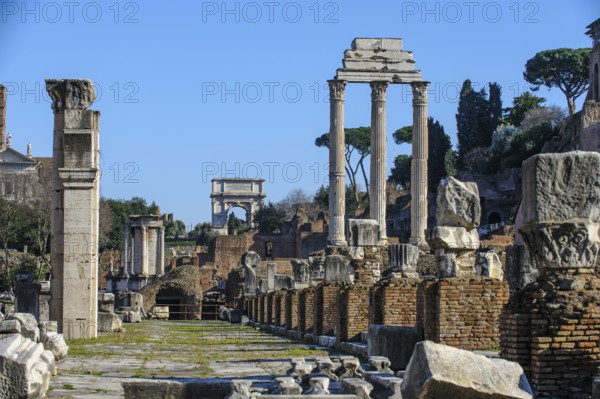 View of Roman Forum through the middle of ruin with foundations of Basilica Basilica Julia Julia right behind the remaining three columns of Dioscuri Temple Temple of Castor and Pollux center back right Arch of Titus triumphal arch of Emperor Titus left next to the ruins of Temple of the Vestals, Roman Forum, Rome, Lazio, Italy