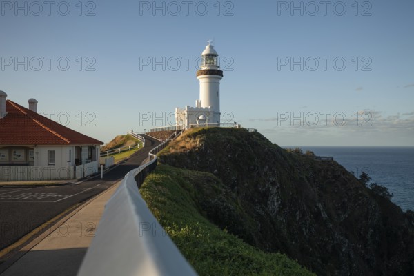 Byron Bay lighthouse on the cape with blue skies and good weather. View from the way to Cape Byron lighthouse with few people