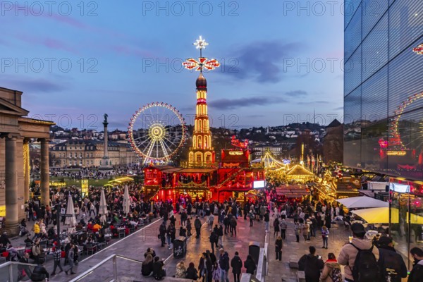 Evening atmosphere at Stuttgart's Christmas market in the Schlossplatz area. With around 3.5 million visitors, it is one of the largest and most beautiful in all of Germany. Christmas pyramid and Ferris wheel in front of the New Castle. Stuttgart, Baden-WÃ¼rttemberg, Germany
