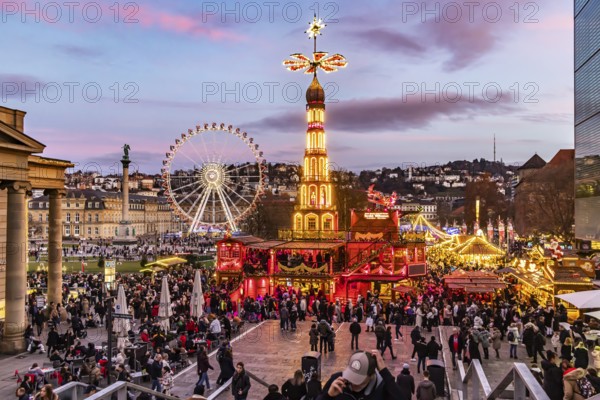 Sunset at Stuttgart's Christmas market in the Schlossplatz area. With around 3.5 million visitors, it is one of the largest and most beautiful in all of Germany. Christmas pyramid and Ferris wheel in front of the New Castle. Stuttgart, Baden-WÃ¼rttemberg, Germany