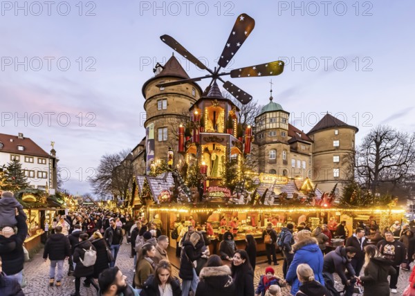 Evening atmosphere at Stuttgart's Christmas market in the Schillerplatz area. With around 3.5 million visitors, it is one of the largest and most beautiful in all of Germany. Christmassy illuminated Christmas pyramid in front of the Old Castle. Stuttgart, Baden-WÃ¼rttemberg, Germany