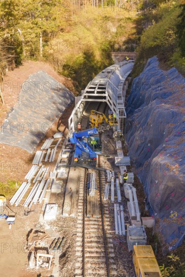 Railway tracks with crane and workers working on tunnels in autumn, Hermann Hesse Railway bat tunnel construction site, Calw, Black Forest, Germany