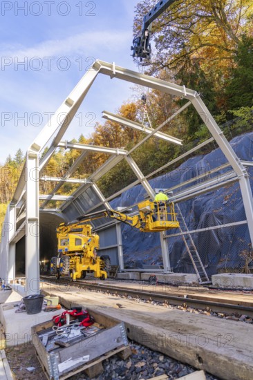 Construction work at a tunnel entrance in autumn with yellow construction equipment and visible nature in the background, Hermann Hesse Railway bat tunnel construction site, Calw, Black Forest, Germany