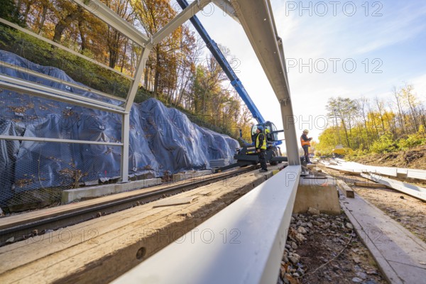 Construction work on a metal structure over railway lines in autumn surroundings, Hermann Hesse Railway bat tunnel construction site, Calw, Black Forest, Germany