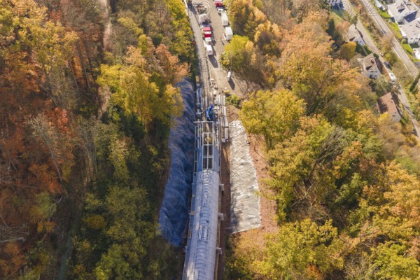 Overview of a tunnel construction site in autumn forest from an oblique bird's eye view, Hermann Hesse Railway bat tunnel construction site, Calw, Black Forest, Germany