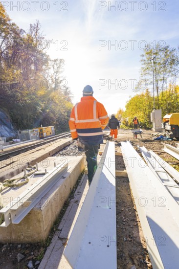 Construction workers in protective clothing walk along a construction site in an autumn scene, Hermann Hesse Railway bat tunnel construction site, Calw, Black Forest, Germany