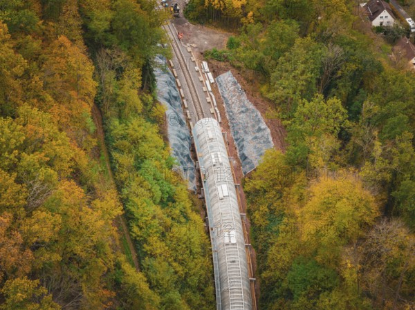 Construction site of a tunnel from above in autumn forest with green and colorful trees, Hermann Hesse Railway bat tunnel construction site, Calw, Black Forest, Germany