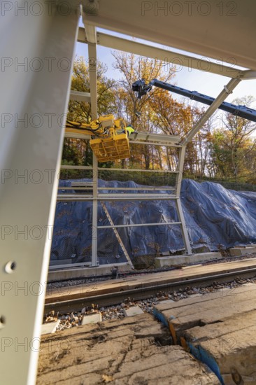 Metal frame construction with crane over tracks in an autumn environment with forest in the background, Hermann Hesse Railway bat tunnel construction site, Calw, Black Forest, Germany