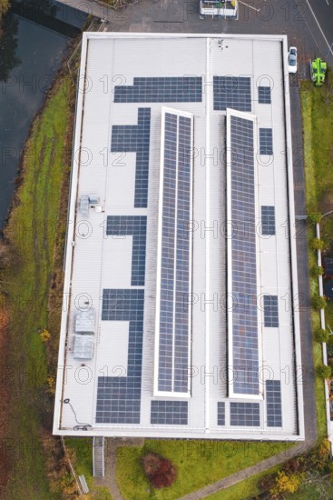 Bird's-eye view of building roof with solar cells in an autumn environment, PV at Walther Lindner Sporthalle Calw, Black Forest, Germany