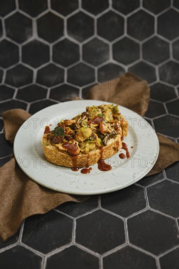 A mouthwatering mushroom sandwich topped with honey mushrooms, enoki mushrooms, and champignon rests on a rustic plate