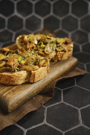 A delicious mushroom sandwich is arranged on a wooden board. The sandwich includes honey mushrooms, enoki mushrooms, and champignon, topped with fried leeks for added flavor