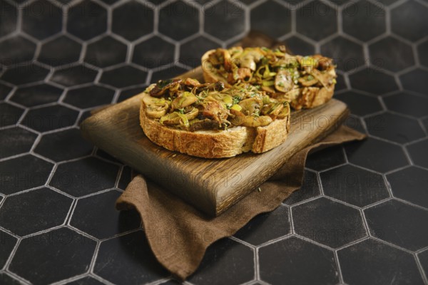 Freshly made mushroom sandwich features honey mushroom, enoki mushroom, champignon, and leek on crusty bread. Served on a wooden board, it looks inviting against a dark patterned background