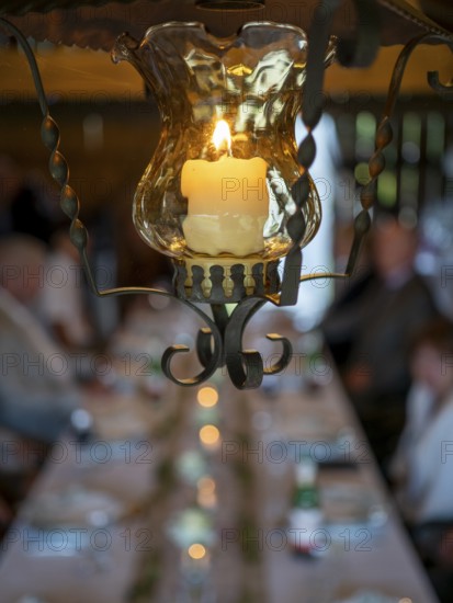 Hanging lamp with candle in old barn at wedding party